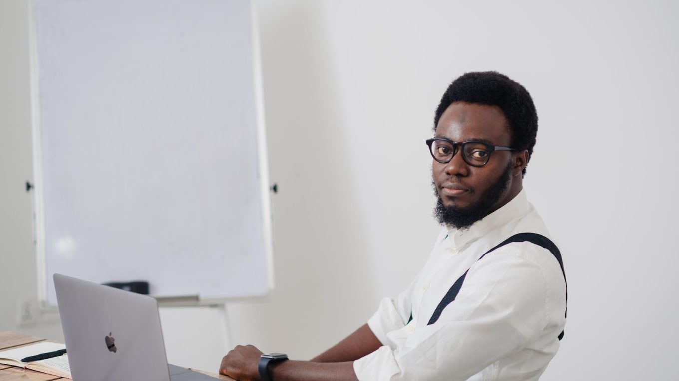 a man sitting at a table with a laptop in front of him